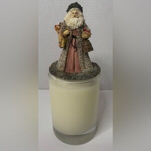 Candle topper with Santa holding a cardinal bird and a backpack of toys stands4"